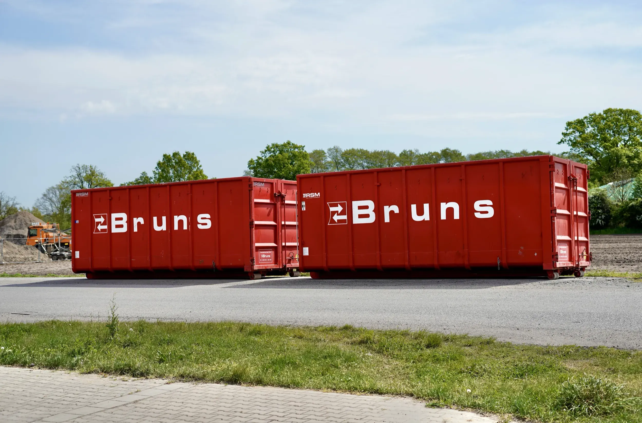 Zwei rote Abrollcontainer von Bruns Transporte auf dem Betriebsgelände